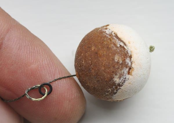 Bevestig een rig ringetje van 3.7mm middels een platte knoop op 1,5 cm van het haakaas